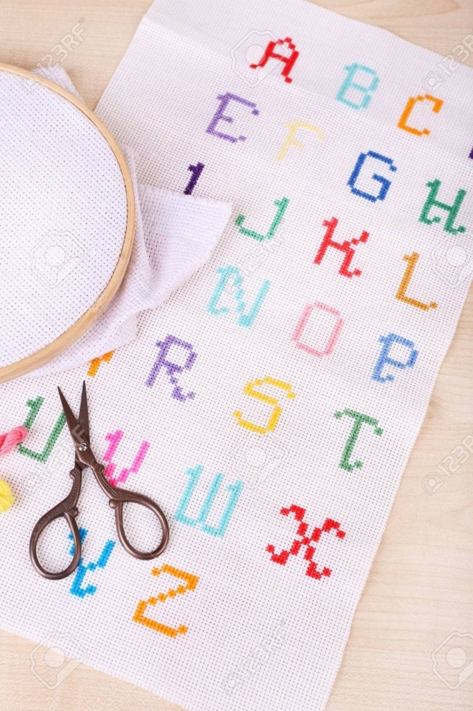 Handmade Embroidered Letters On White Fabric And Scissors On..